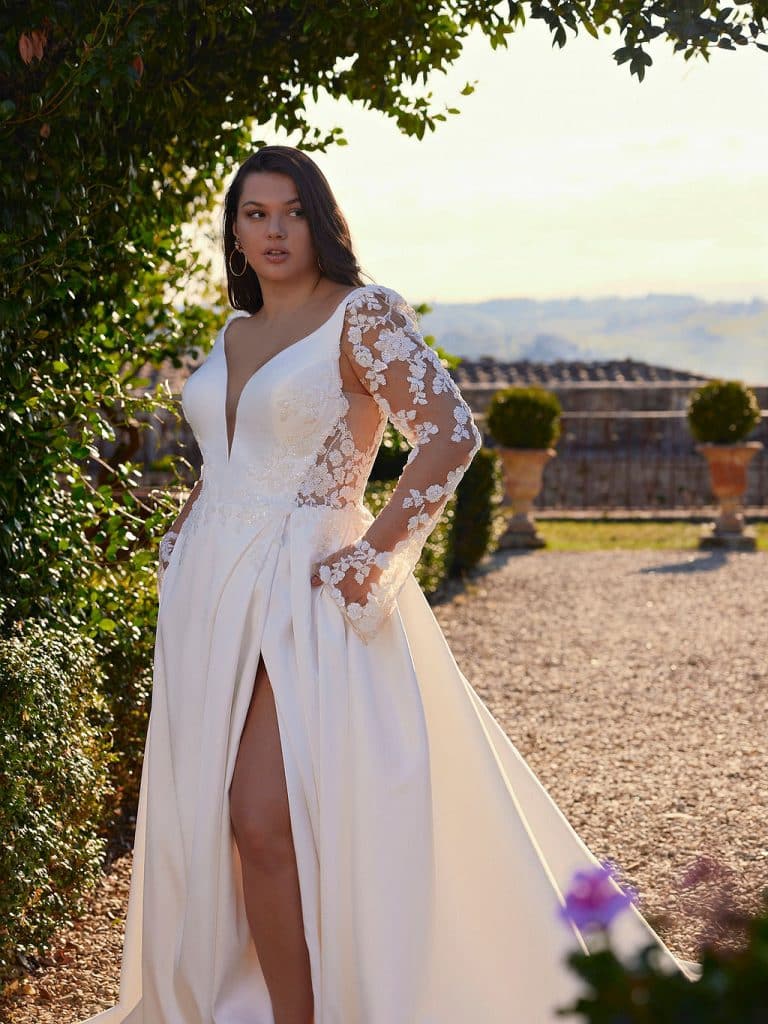 Trouwjurk Dottie-C met mikado stof, bewerkte kant, afneembare lange mouwen, split in de rok voor een elegante en gedurfde bruidlook.