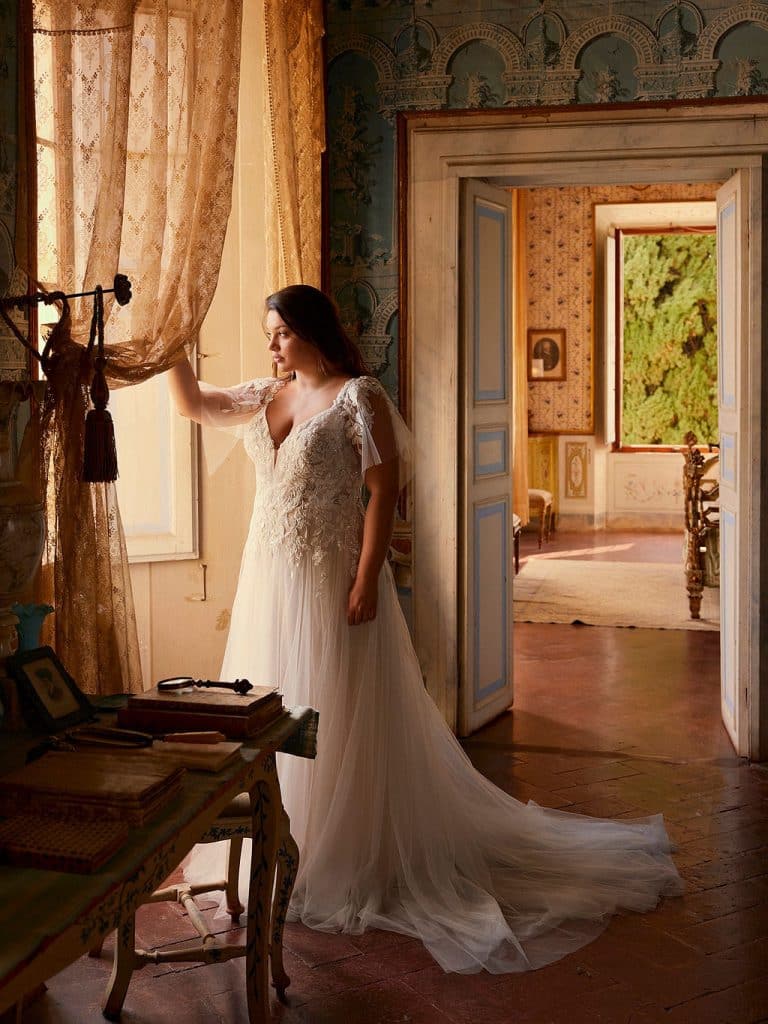 Trouwjurk Eloise-C met A-lijn silhouet, sprankelende tulle rok, sequins kant en afneembare fluttermouwen voor een elegante en veelzijdige uitstraling.