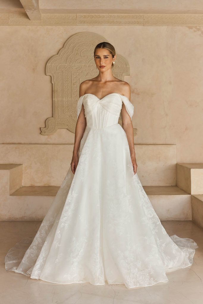Strapless ballgown trouwjurk Lawson van Madi Lane met bloemenorganza, sweetheart lijfje, open korset, afneembare schoudermanchetten en A-lijn rok met zakken.