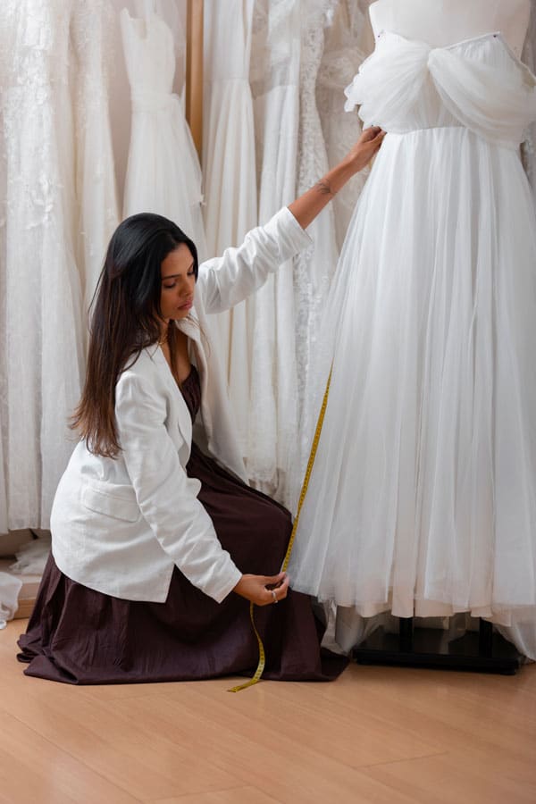 Werkneemster meet een bruidsjurk op bij Charmé Bridal in de regio Tilburg