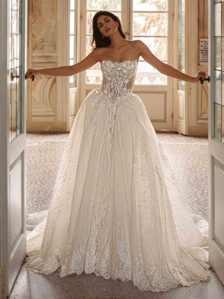 Waylen trouwjurk met strapless kanten corsetlijfje, 3D-bloemapplicaties, puntige taille en volumineuze kanten rok.